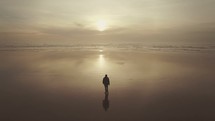 man walking along a shore 