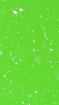 Vertical video of snow snowing on green screen background

