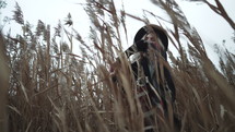 Stylish woman dancing among reeds