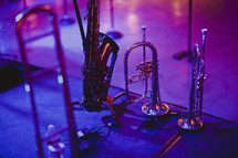 A saxophone, trumpet and horns sitting on a stage