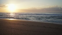 tide washing onto a beach at dawn 