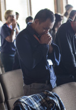 parishioners in prayer during a worship service 