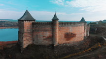 Panorama aerial view of old castle Hotin near river. Khotyn Fortress - medieval castle on yellow autumn hills. Ukraine, Eastern Europe. Architecture of Middle Ages in our time.