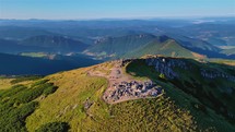 Panorama of alpine mountains peak in sunny morning nature at sunrise, aerial view
