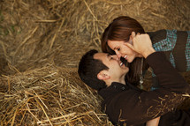 a couple kissing in hay