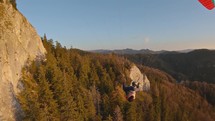 Calm paragliding flight over rocks and forest in autumn mountains nature, freedom adventure
