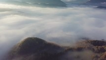 Morning flight above foggy landscape in autumn. Tilt up slow motion time lapse
