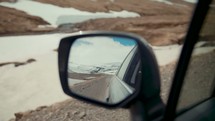 view of snow on mountains in a rearview mirror 