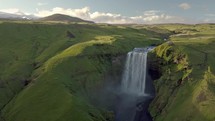 Skogafoss waterfall in green Iceland landscape.
