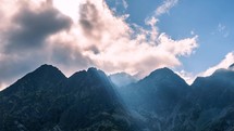 Mystic light of sunrays and clouds motion over misty alps mountain landscape Time-lapse
