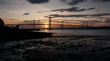 Forth bridge in Scotland at sunset with clouds in the sky