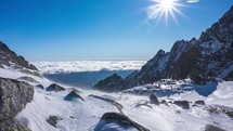 Winter Alps mountains in beautiful sunny day with strong wind and low clouds motion in valley Time lapse Nature

