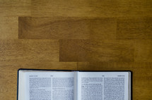 edge of a Bible on a wood table