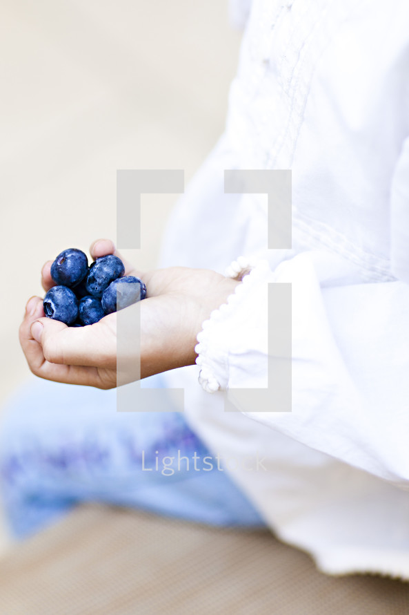 Girl holding blueberries