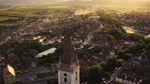 aerial view over town and tile roof church 