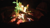 Medium panning shot of strange fire with green, blue, and orange flames. 