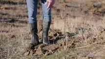 A Man in Boots Compacting the Soil with His Feet - Close Up	