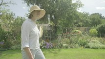 Steady cam view of a senior caucasian woman walking through her garden themes of retirement seniors gardening hobbies