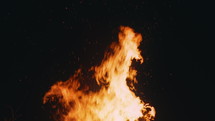 Tree branches burning in a campfire at night in slow motion