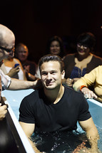 A smiling man being baptized content joy 