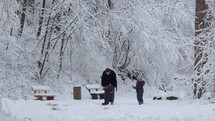 father playing with his children in the snow 