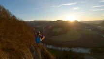 Adventure Flying proximity by rocky cliff in spring nature at golden sunset, paragliding beauty
