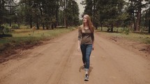 woman walking down a dirt road 