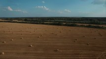 aerial view over hay bales in a field 