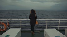 a woman on a ferry looking out at the water 