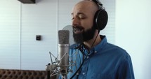Man singing into microphone in studio