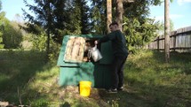 a man lifts a bucket of water from an old village well on a chain. An old primitive method of extracting fresh water. Access to drinking water