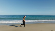 Pensive Man Running Sport On The Sandy Beach Near Ocean