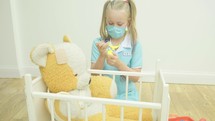 a little girl playing doctor with her toys 