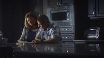 a couple reading a Bible together in a kitchen 