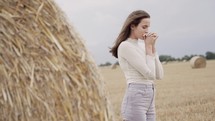 woman praying next to a hay bale 
