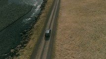 aerial view over an SUV traveling on a dirt road 