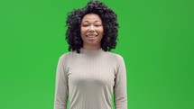 Woman on green screen smiling and nodding awkwardly