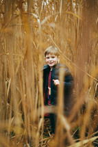 a boy hiding in a field of tall grass 