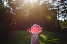 a little girl holding up a paper stop sign 