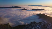 Beauty of morning light of sunrise in winter alpine mountains landscape with foggy clouds in valley High Aerial view

