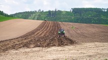 Tractor plowing a field, deep plow tillage cultivate soil in spring natural agriculture farming
