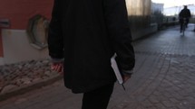 man walking carrying a Bible 