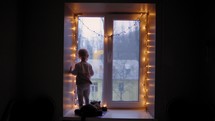 Child Looking out Window During Snow.