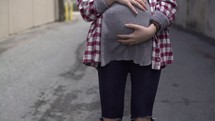 teen pregnancy, pregnant teen walking outdoors 