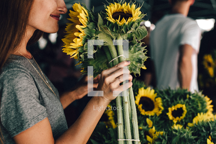 a woman picking out sunflowers 