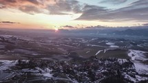 Aerial view of sunset over low land country and small village.
