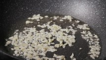 Frying Garlic In A Pan - Close Up