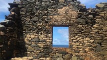 ocean view through window of a building in ruins 