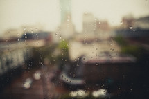 A blurry view of a city through a rain covered window