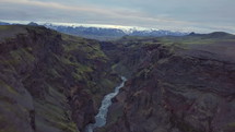 Fly up from dark volcanic canyon in Icelandic mountains

